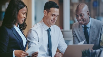 Two business professionals smiling and reviewing a report together on a tablet, representing collaborative consulting and senior team involvement