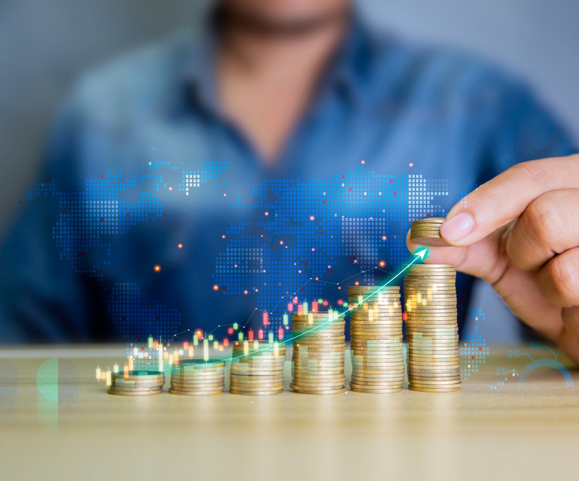 A person pointing to a rising bar chart displayed on a digital screen, with stacks of coins in the foreground, representing financial growth and ROI